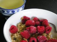 Granola cereal with cranberries, raspberries, almond milk, and green tea