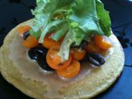 Socca with tahini, tomatoes, black olives, mixed greens, and rosemary